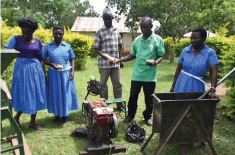 Chairperson Otwani Terensio (middle), Hellen Epuruge (far right) and other members of the Nyarakot Group showcasing their machines.