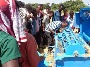 Furi Hirpo showcases one of his multi-crop threshers to a group of smallholder farmers in the Oromia Region of Ethiopia