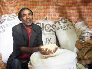 Smallholder farmer Ato Tesfaye Andualem with his surplus maize grain stored in PICS bags