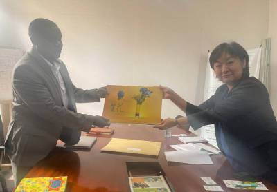 The First Secretary handing over a Japanese calender to the Country Director during the meeting