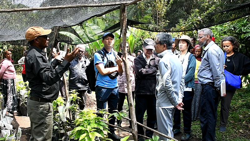 During his visit to a project site, SAA President Shuichi Suzuki (right) listens as Dr. Fentahun Mengistu, Country Director of SAA-Ethiopia (left), explains local initiatives to promote sustainable agricultural practices.