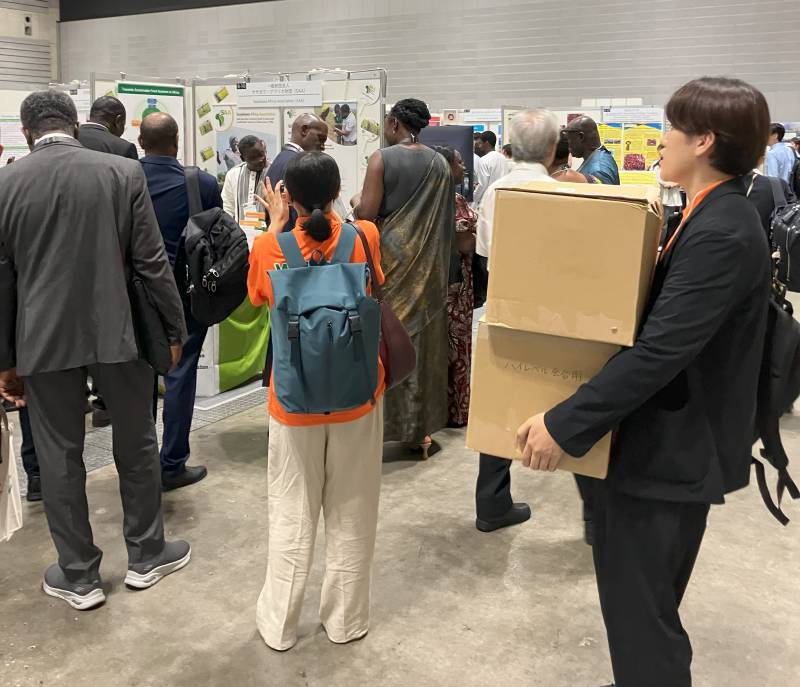 Intern K carrying flyers to the exhibition booth