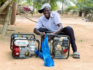 Mr Yusuf Ijeh displays his water pump machines acquired from sales of rice paddy under the PHRDG I project during a visit to his home by the PHRDG 1 team.
