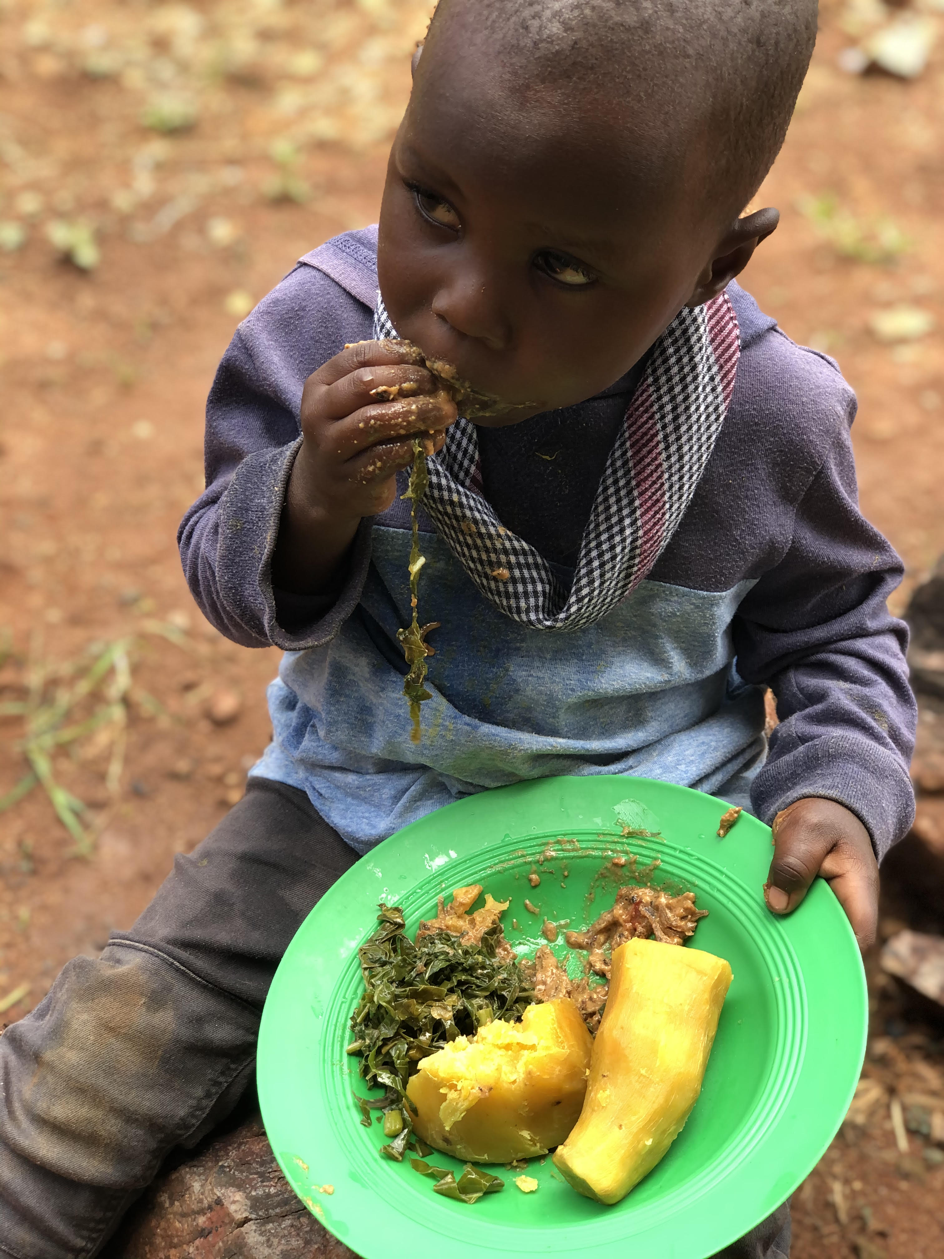 A child enjoying vitamin A sweet potatoe and vegetables in Bugiri district, Uganda