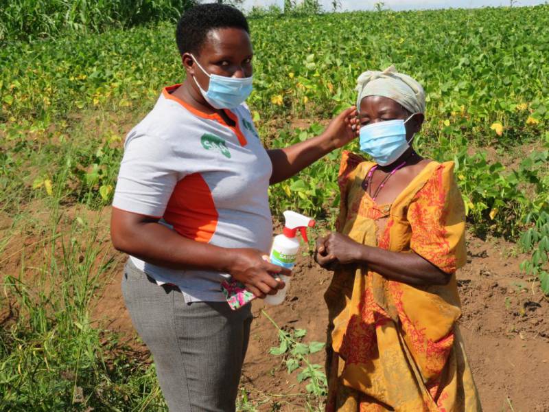 （ウガンダ）農民に対しマスク着用と消毒を促し、農業指導を行うSAAスタッフ